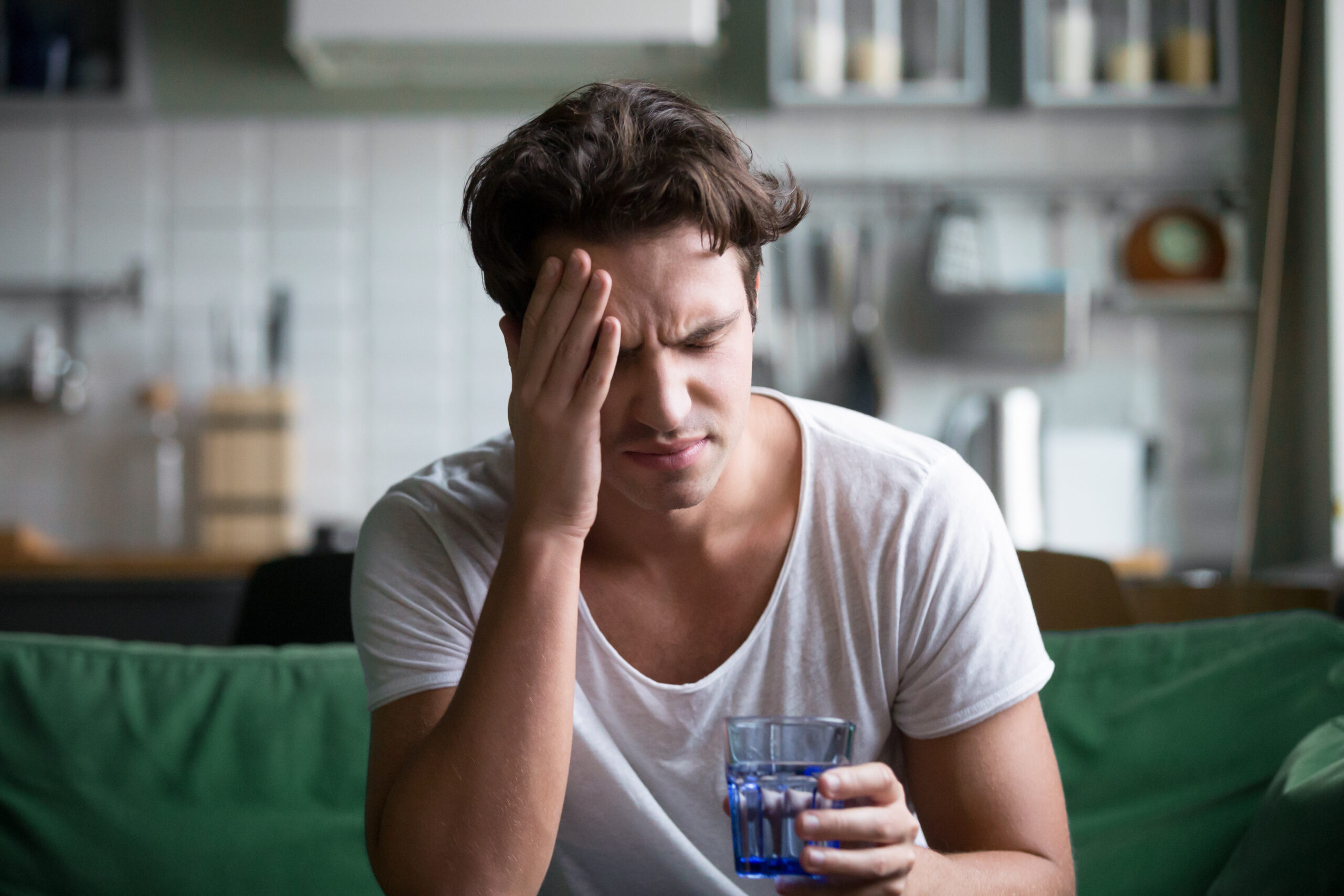 young man dealing with a hangover headache